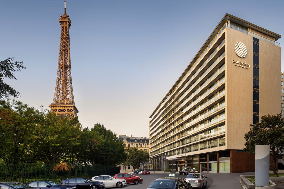 Pullman Paris Tour Eiffel facade with the Eiffel Tower beside the hotel.